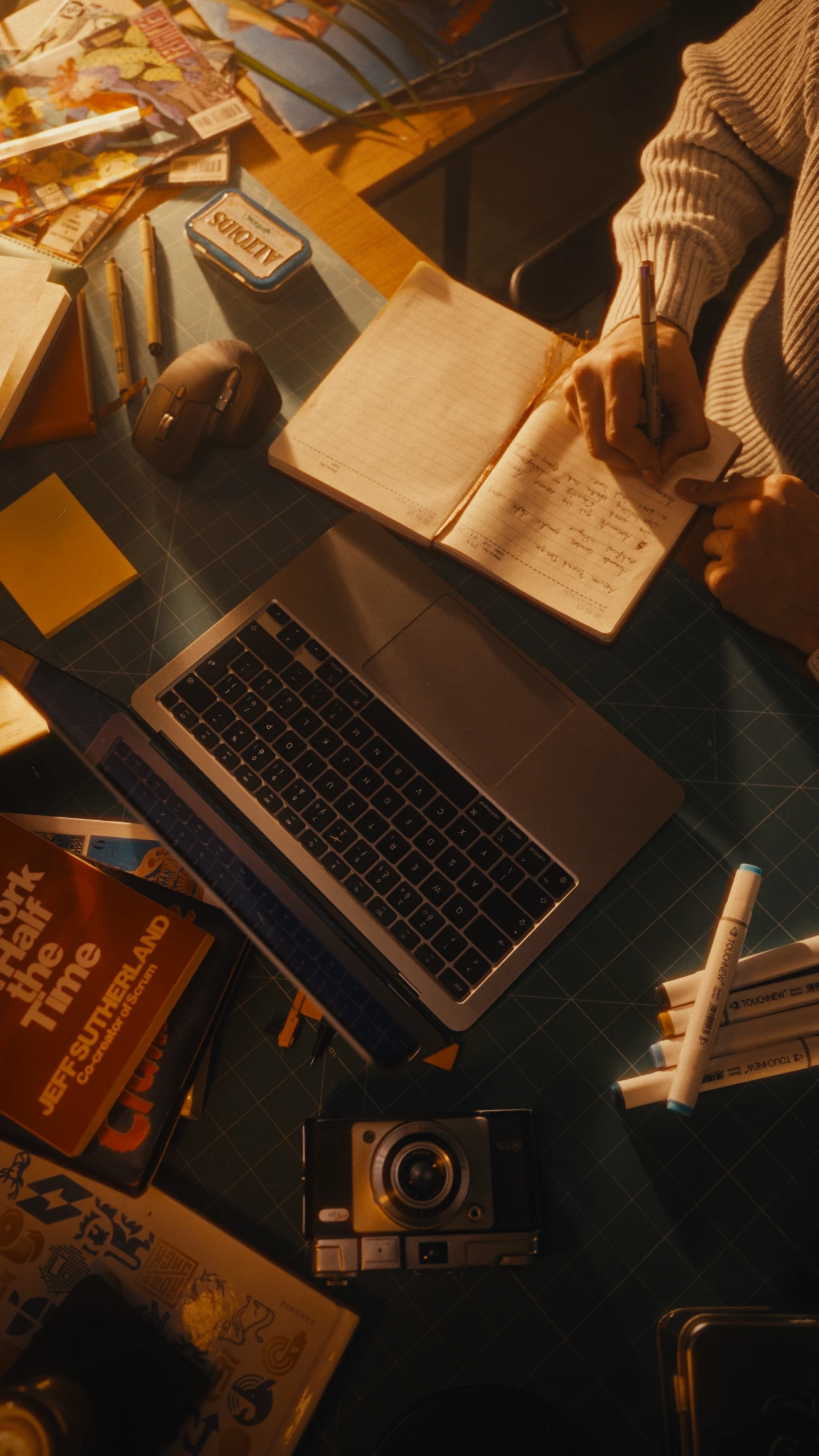 Notes in a notebook beside the laptop at the studio desk